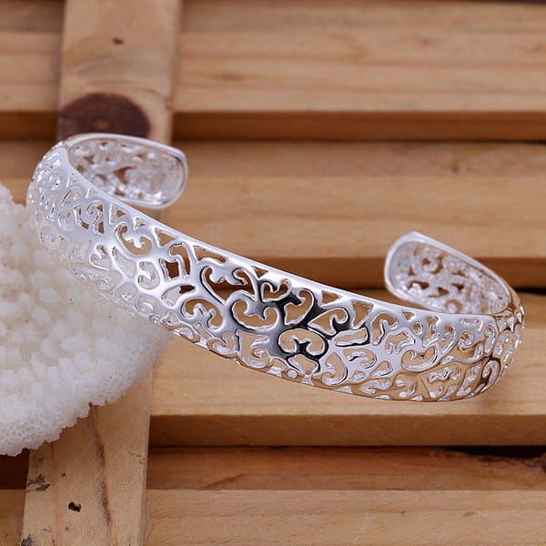 Sterling silver filigree cuff bracelet with an intricate open design in silver.