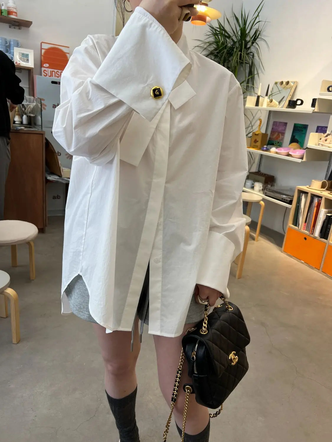 light blue oversized button up shirt featuring a white oversized button-up design with gold-tone buttons and a structured collar.