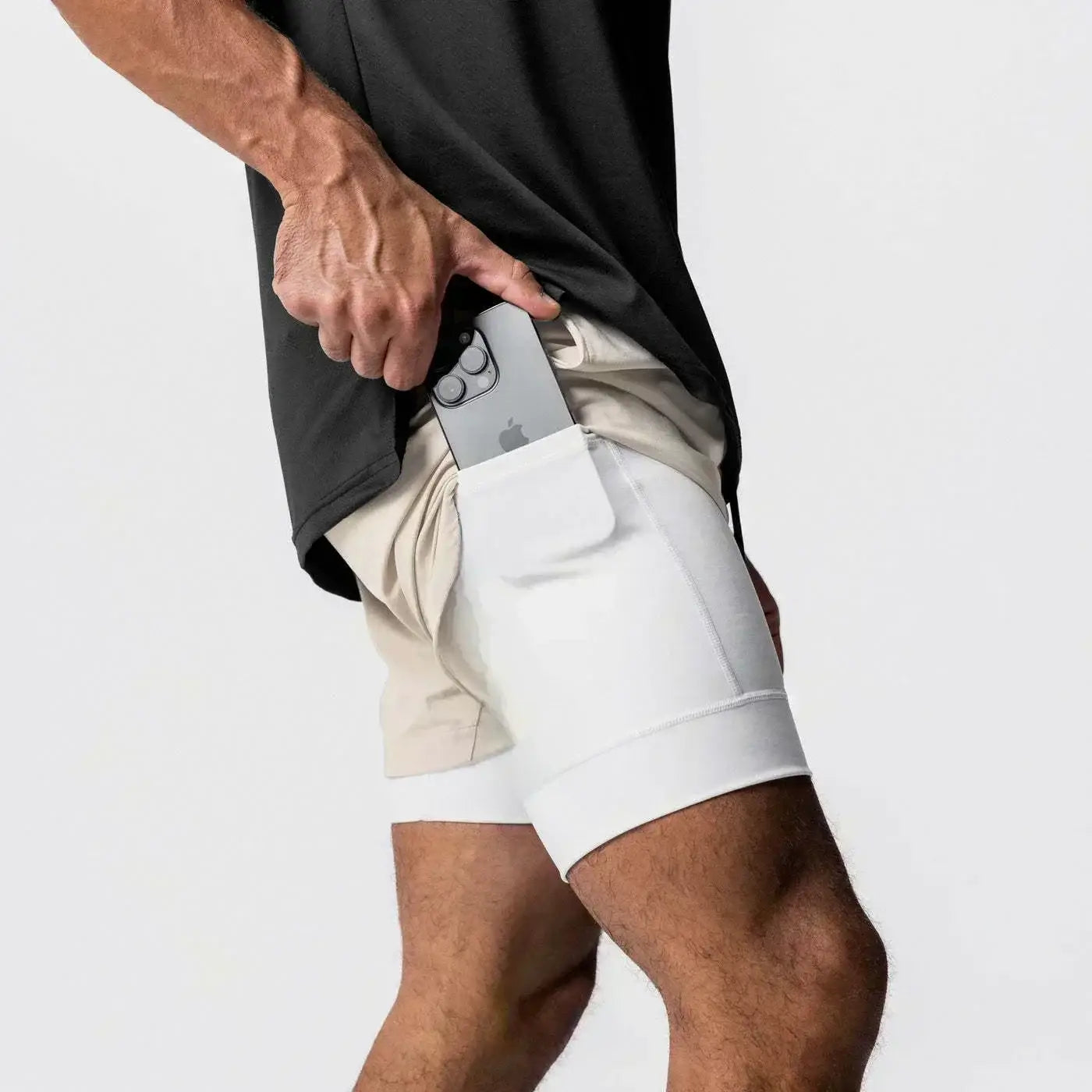 Hombres, pantalones cortos atléticos blancos para gimnasio con cintura elástica y trabilla para la toalla, que incluyen un bolsillo integrado para un teléfono inteligente.