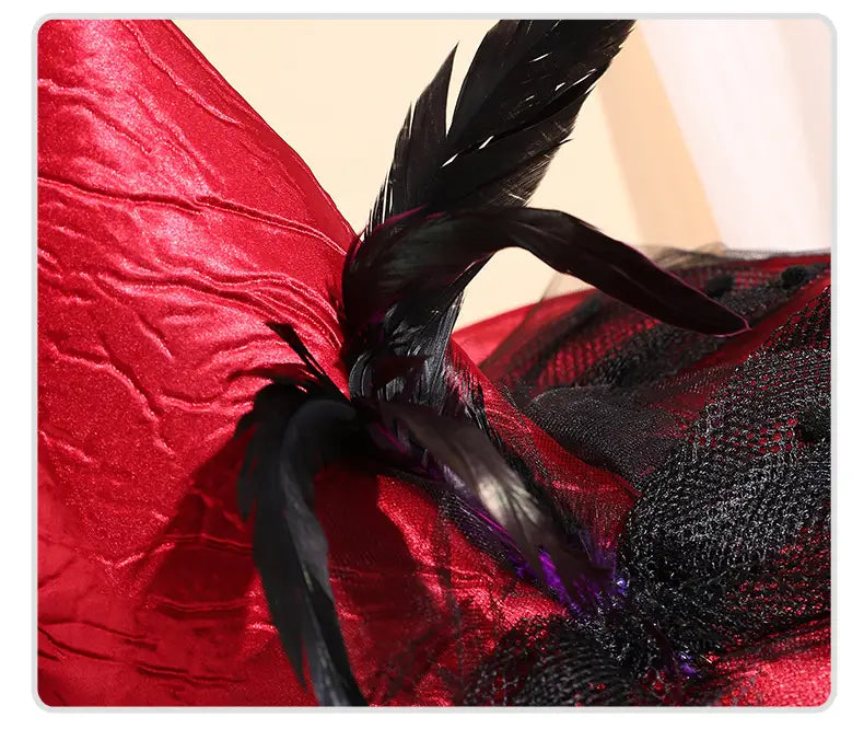 Chapeau de sorcière rouge réalisé dans un tissu de velours rouge saisissant, agrémenté de plumes noires et de détails élaborés en maille noire.