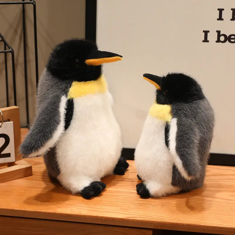 Soft plush penguin stuffed animal soft toy pair with black heads, yellow beaks and neck collars, gray wings, white bellies, and black feet.