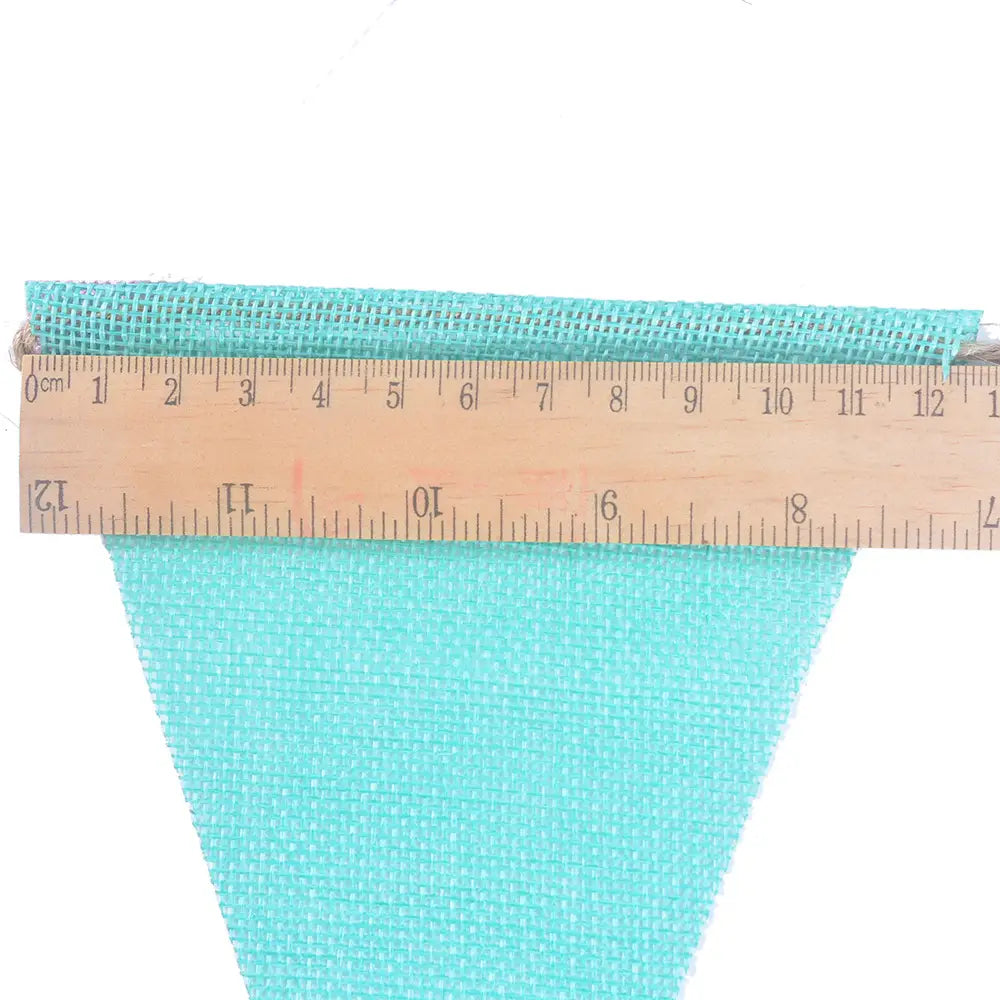 Ruban en toile de jute tissée turquoise d’environ 12 centimètres de largeur, utilisé dans une guirlande de décoration de fête en feutrine pastel.