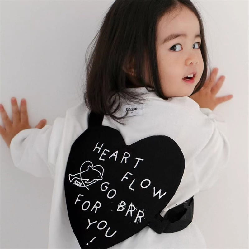 Schwarze herzförmige Kinder-Umhängetasche aus Korea mit weiß besticktem Text und kleinem Wal-Design.
