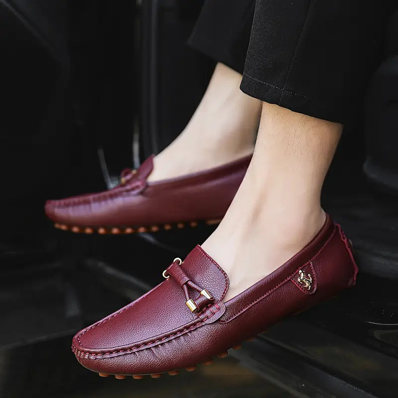 Les chaussures à enfiler habillées en cuir pour hommes se portent sans effort avec des chaussures décontractées en cuir bordeaux, avec un détail de nœud ton or et des coutures contrastées.