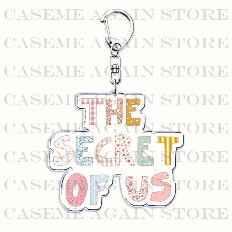 A colorful patchwork-style acrylic keychain featuring the phrase the secret of us in multi-colored lettering designed as a Gracie Abrams anime fan gift.