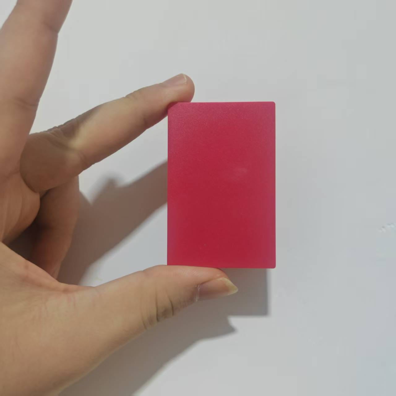 A solid rectangular pink silicone eraser held in hand as an accessory case for game card storage box v2.