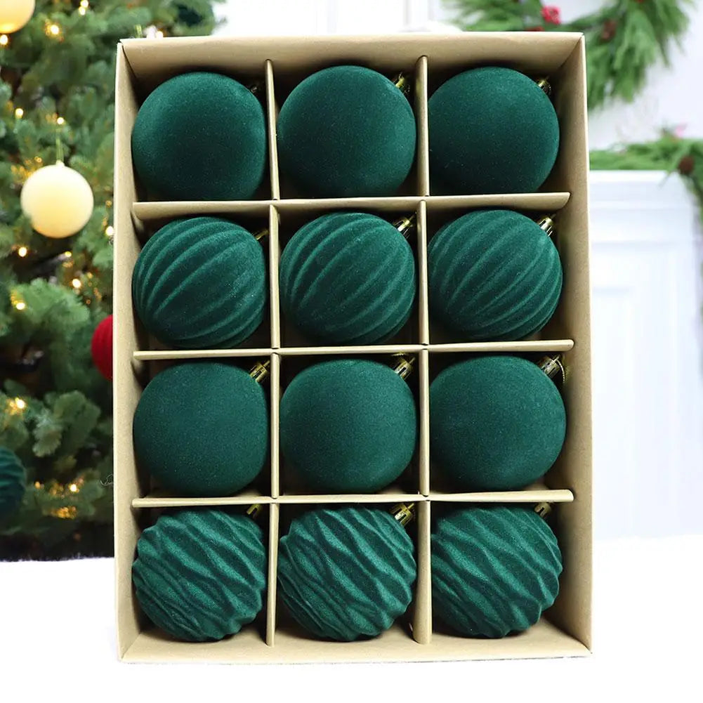 Ein Set mit zwölf Christbaumkugeln in tiefgrünem Samt mit gerippten und glatten Texturen, in einer Pappschachtel liegend