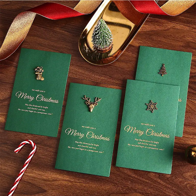 green christmas greeting cards set with gold foil lettering and small metallic holiday charms featuring gold foil envelopes.