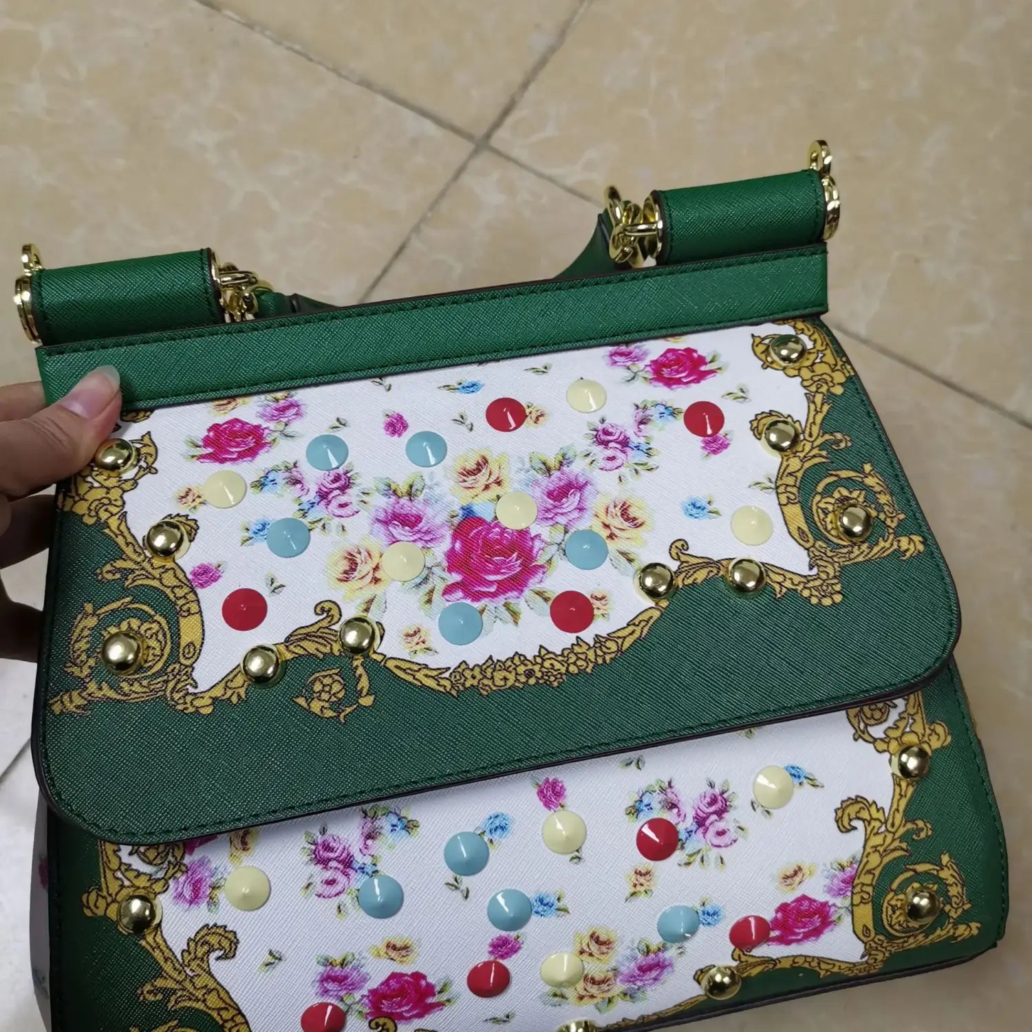 Sac bandoulière en cuir vintage, art raffiné, en cuir floral vert et blanc, avec quincaillerie ton or et des clous décoratifs.