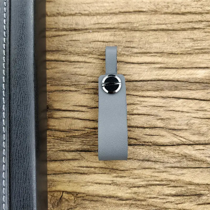 Genuine leather car keychain in gray with a silver-toned circular clasp featuring a black center and metal key ring set.
