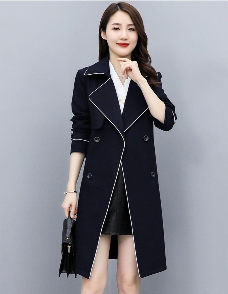 Black women double breasted trench coat with white contrast stitching and classic tailored design.