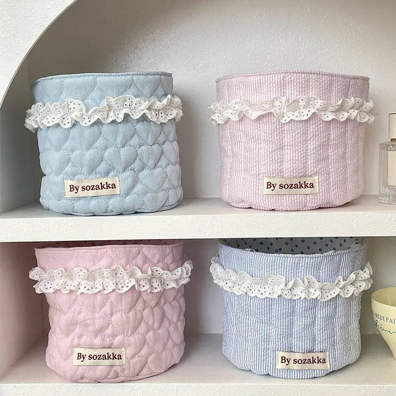 Pastellfarbene gepolsterte Aufbewahrungskörbe für das Kinderzimmer mit weißem Spitzenbesatz und von Sozakka-Schildern aus Stoff.
