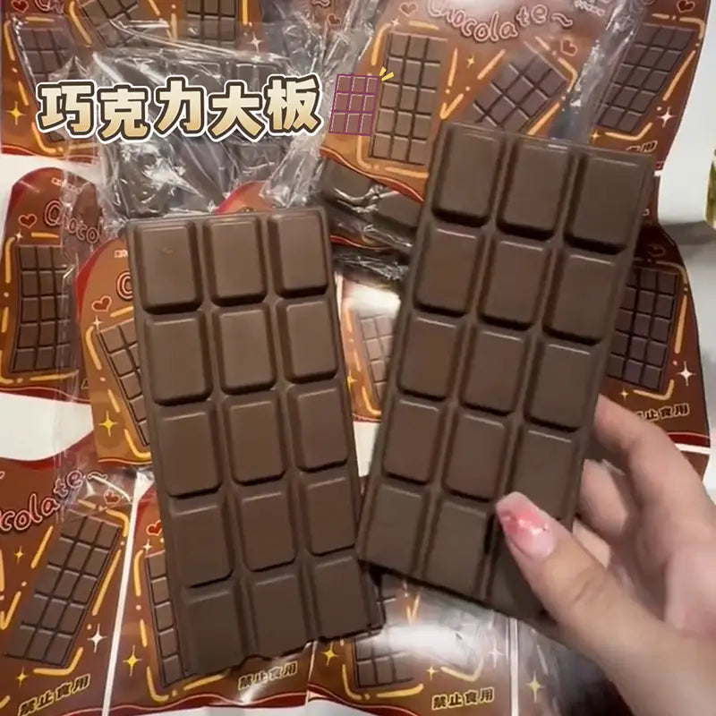 dark brown rectangular chocolate bar squeeze toy with a glossy finish and grid of square segments designed as a slow rising sensory fidget.