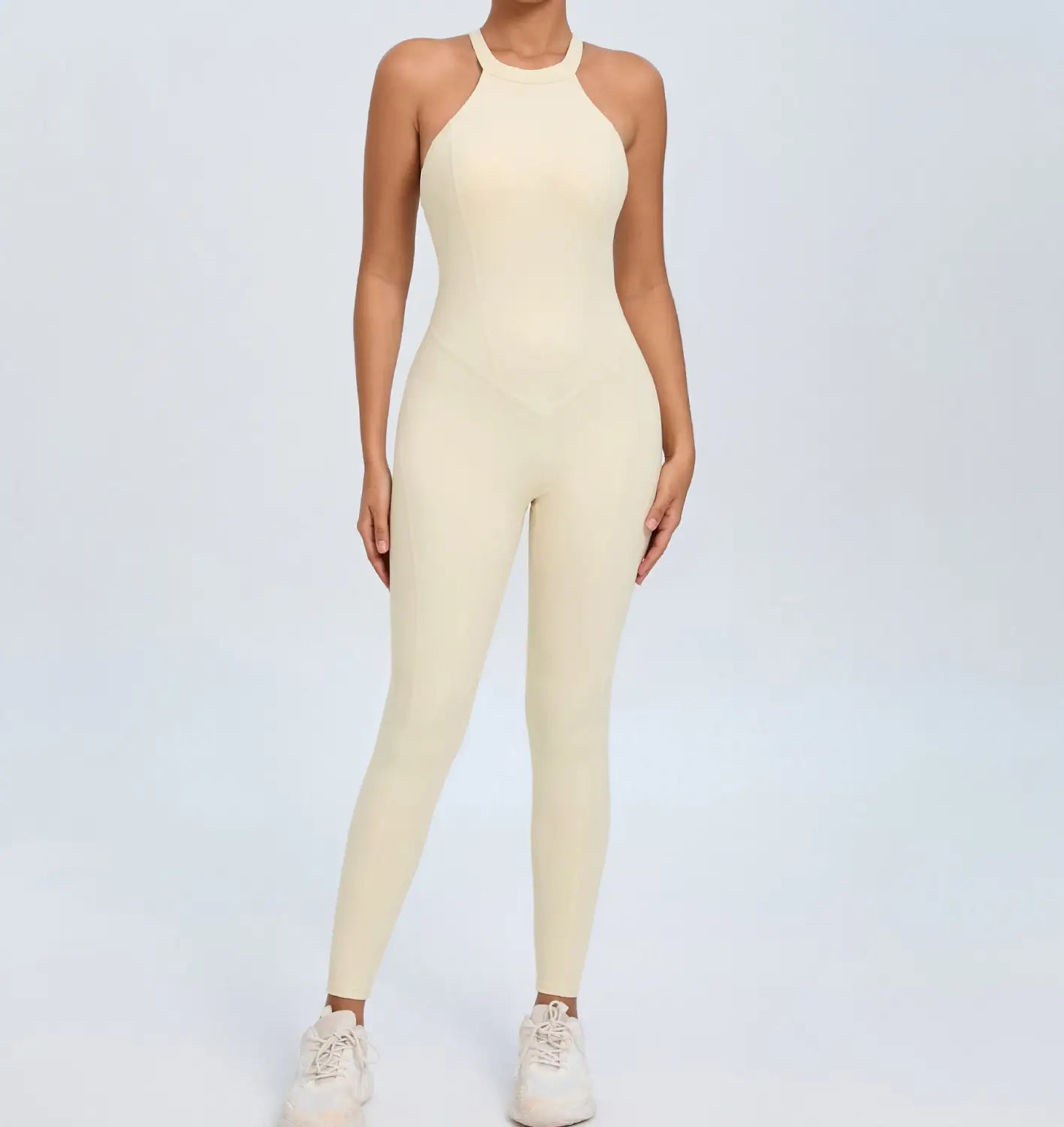 Cream-colored seamless form-fitting high-neck workout jumpsuit with an open back designed for athletic use.