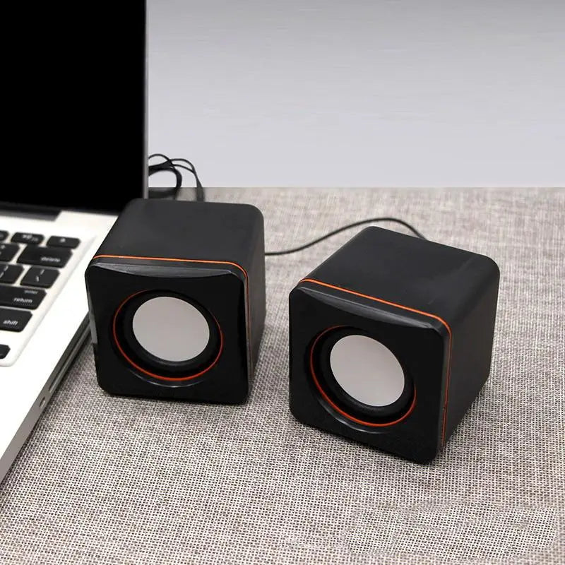 black cube-shaped usb wired led computer speakers with orange trim around circular drivers for stereo pc audio use
