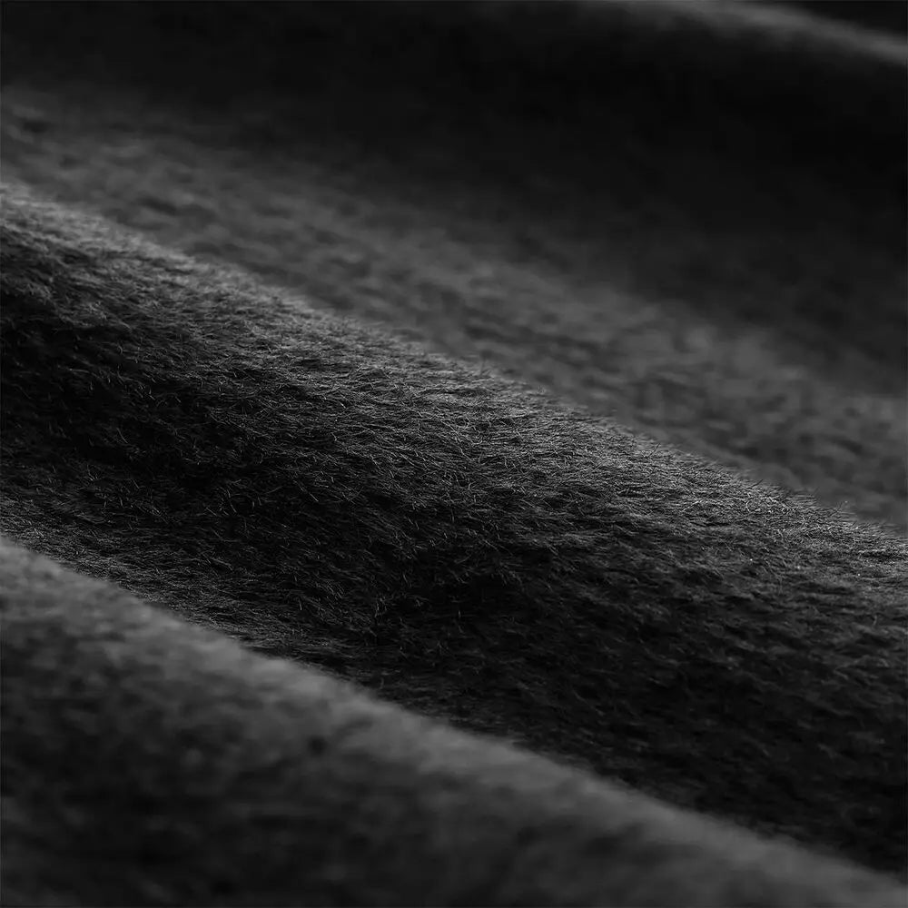 Weiches dunkelgraues Wollmaterial mit einer plüschigen, strukturierten Oberfläche, präsentiert auf einer maßgeschneiderten Laptoptasche mit mehrsprachigem Text für eine Polyestertasche