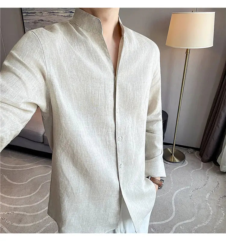 A light beige men’s linen shirt with a mandarin collar and button-down front suitable for casual and formal wear.