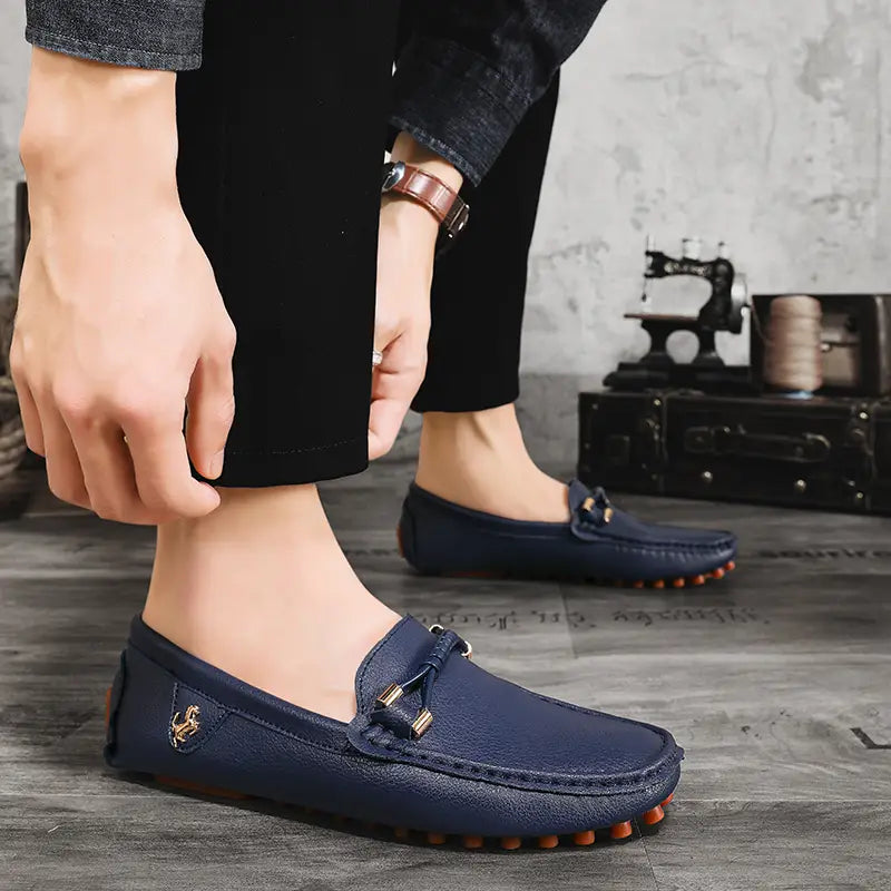 Chaussures à enfiler habillées en cuir bleu marine pour hommes, se portant sans effort avec des chaussures décontractées, avec des accents métalliques ton or et une semelle texturée.