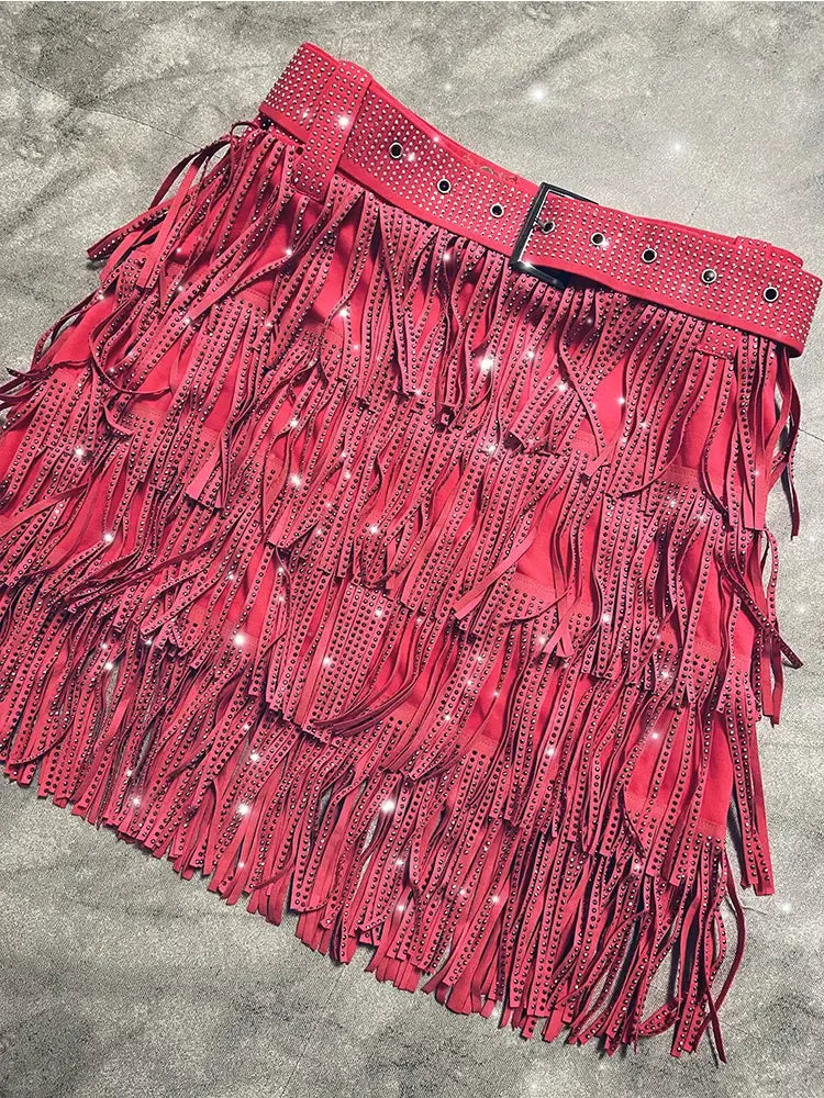 Mini-jupe taille haute rouge vif en suède à franges en strass, avec ceinture assortie et finitions perforées.
