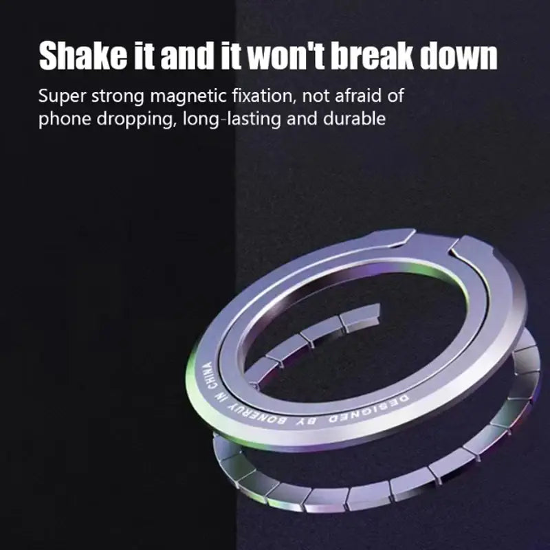 Anillo soporte metálico magnético plateado para teléfono MagSafe con diseño de anillo magnético y bordes segmentados, mostrado desde el lado posterior.