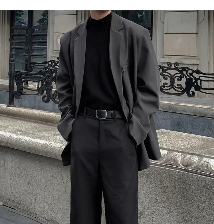 Blazer oversize negra con ajuste relajado y hombros estructurados, hecha de poliéster, en estilo de chaqueta de traje de doble botonadura casual para hombre.