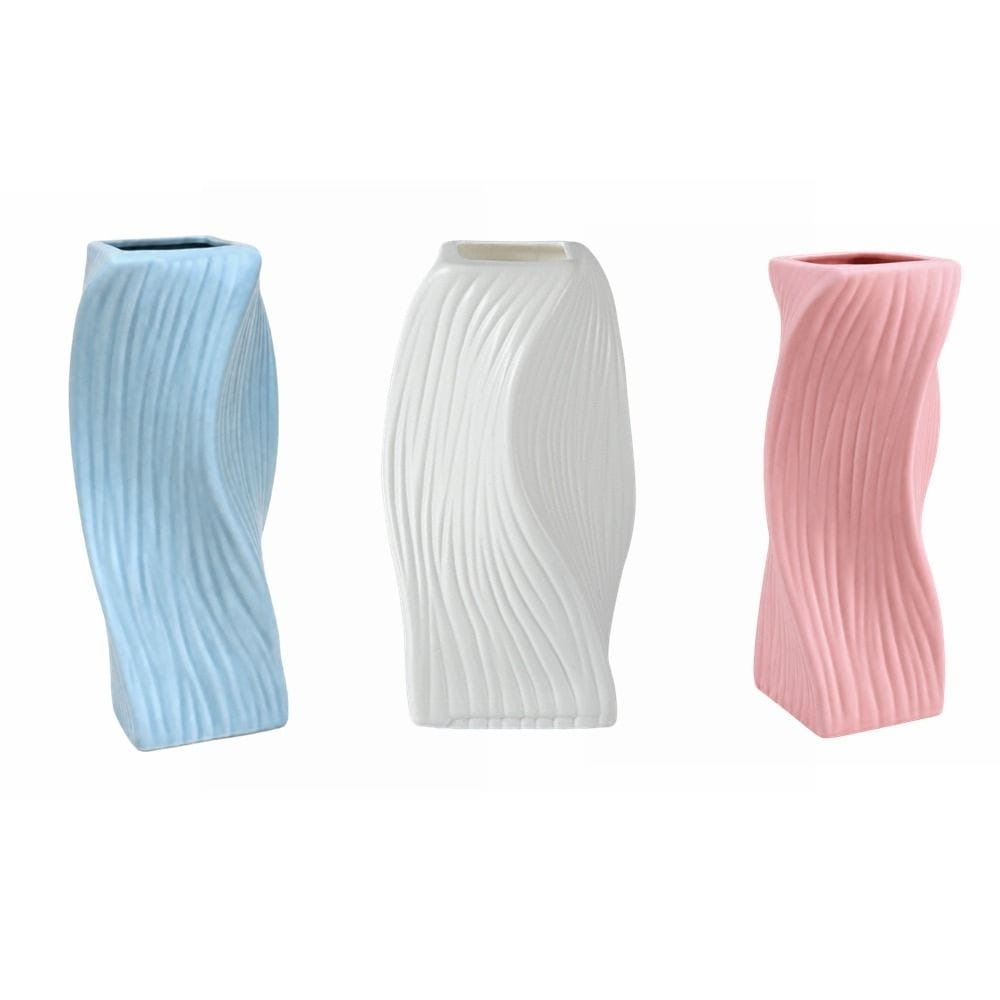 Three slender twisted ceramic Nordic wave plastic flower vases in soft blue white and pink with vertical ribbed texture for aesthetic home decor.