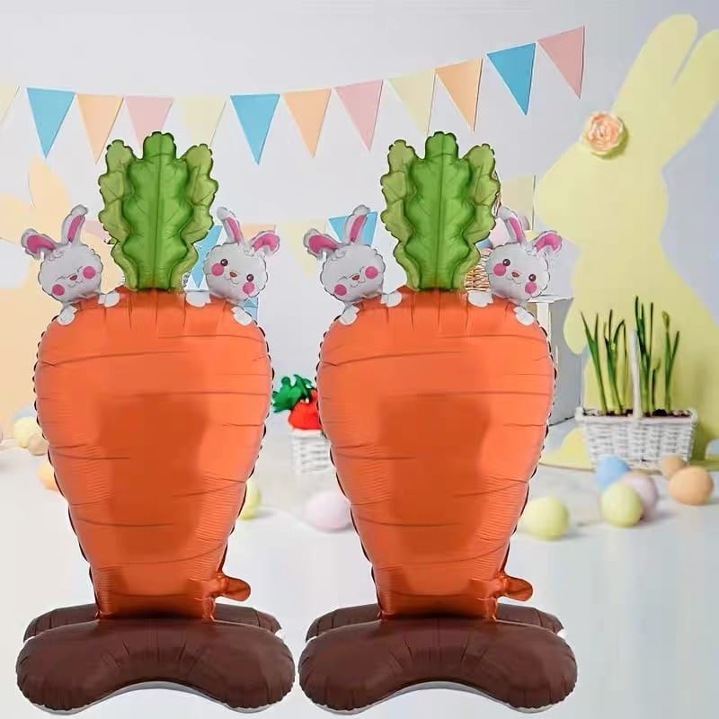 Deux ballons-bijoux en feuille en forme de carotte orange avec des fanes vertes et des visages de lapin blancs sur les côtés pour la décoration de fête de ballons-bijoux en feuille « Lapin de Pâques ».