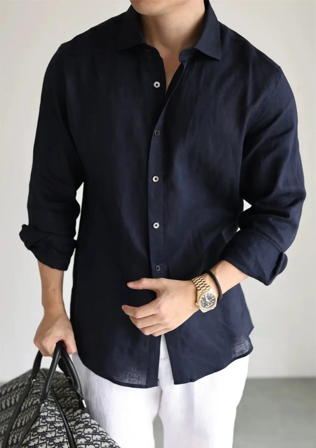 Navy blue men cotton linen casual button down shirt with white buttons and rolled-up sleeves.