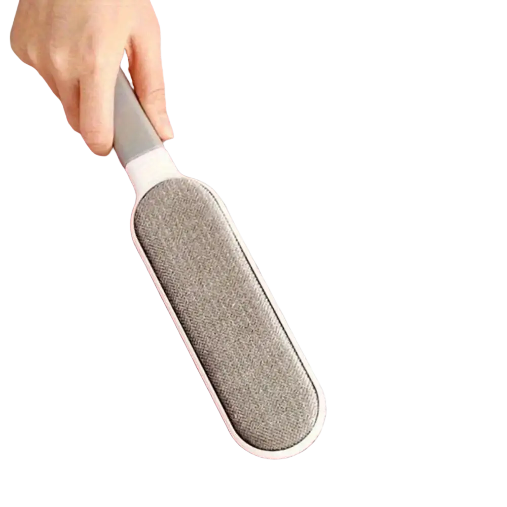 Gray fabric-covered double-sided pet hair remover with white handle removing pet hair from pink knitted surface