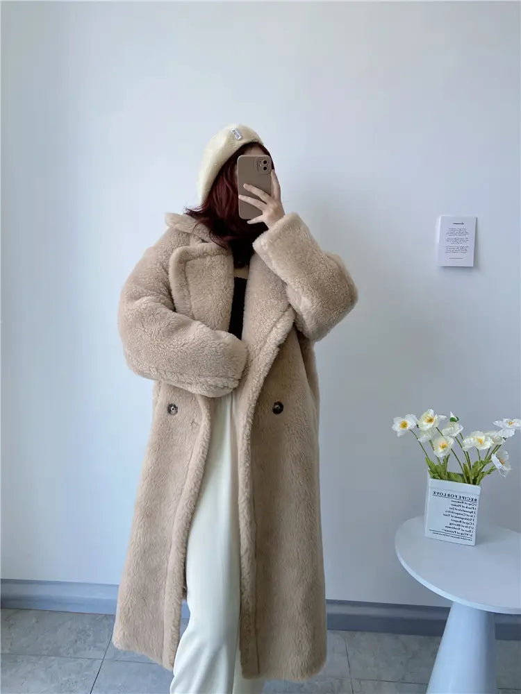 Abrigo exterior tipo osito de peluche largo para mujer de lana con piel sintética color beige, con textura suave esponjosa y diseño cruzado clásico de doble botonadura, que destaca los detalles del contorno de pecho y del contorno de cadera para consultas de servicio de atención al cliente.