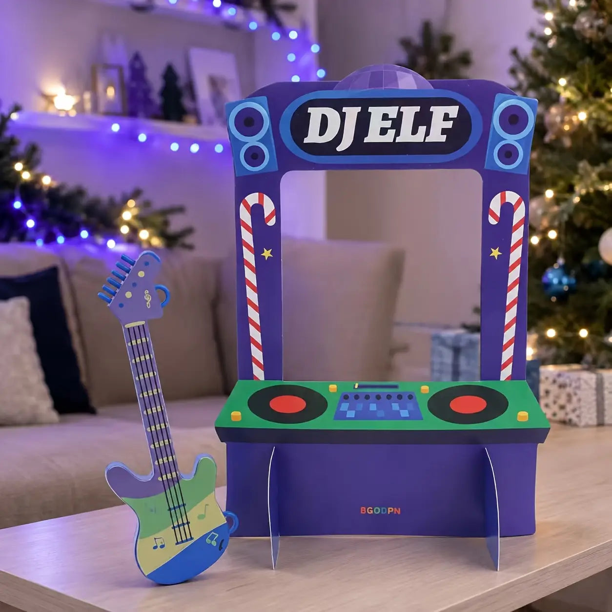 キャンディケインの側面装飾と緑色のターンテーブル式コンソールを備えたパープルの段ボール製DJエルフ筐体。ホリデービレッジの展示用、クリスマスエルフ装飾セット。
