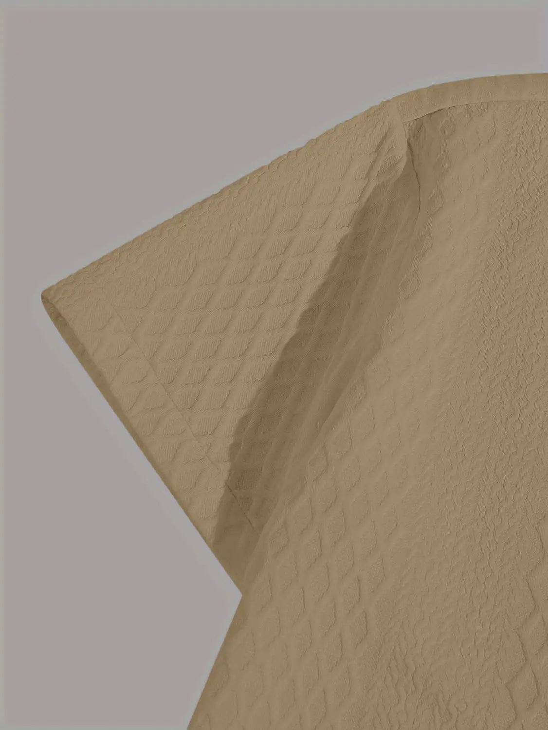 papier beige texturé avec gaufrage discret à motif losange, associé à un haut gris en maille diamant à manches courtes mettant en évidence la texture du tissu et les détails du motif
