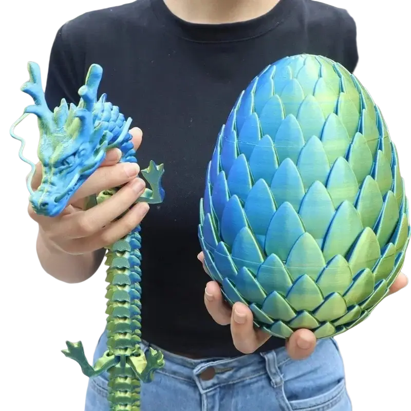 A vibrant blue and green gradient 3d printed dragon egg with detailed scales held beside a matching dragon figurine for home decor