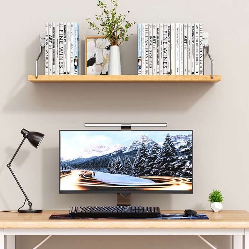 Lampe de bureau murale à col d’oie noire, finition mate et bras réglable, montée sur une étagère murale flottante en bois dans un salon, espace applicable