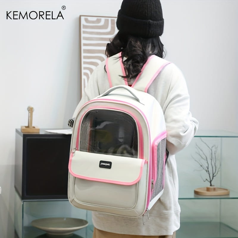 Mochila para transportín de mascotas Kemorela blanca y rosa con panel frontal transparente y diseño plegable de malla gris para ventilación y portabilidad sencillas.