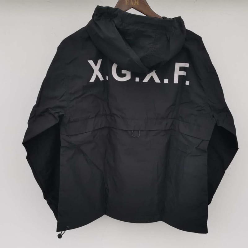 Veste tactique techwear noire à capuche, imperméable, avec matériau imperméable et lettrage blanc x.g.a.f sur le côté arrière.