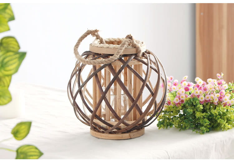 Un porte-bougie en bambou tissé, avec un cadre en bois naturel rustique et une poignée en corde brune, présentant un motif en treillis complexe autour du centre en verre transparent, idéal pour la décoration intérieure du domicile et recevant des avis positifs.