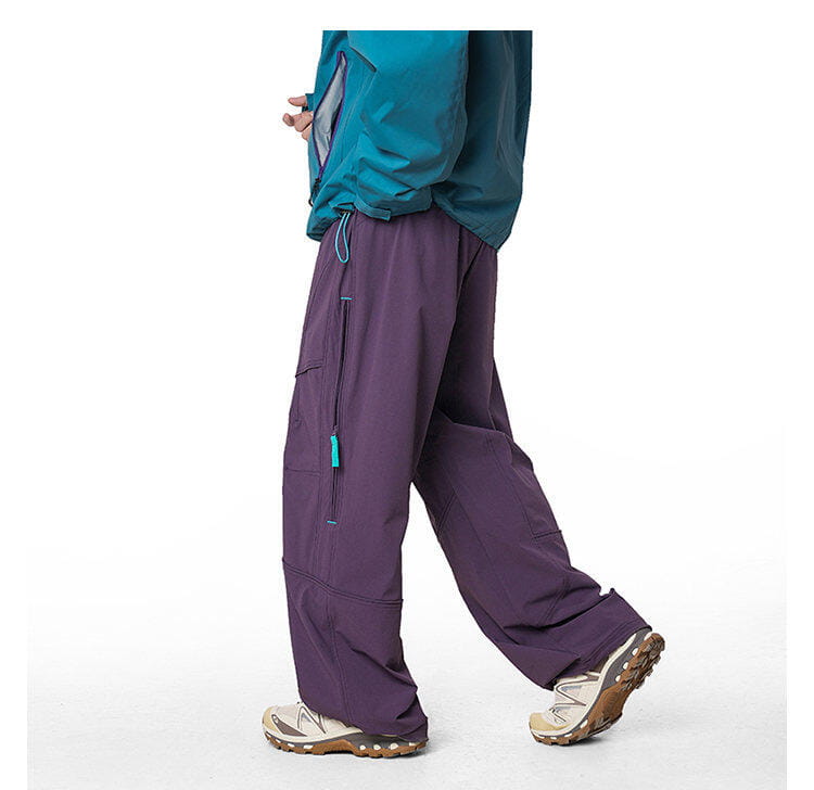 pantalones cargo impermeables de senderismo para hombre en color morado, con detalles de cremallera verde azulado y un corte ancho y relajado de pernera, diseñado para secarse rápidamente.