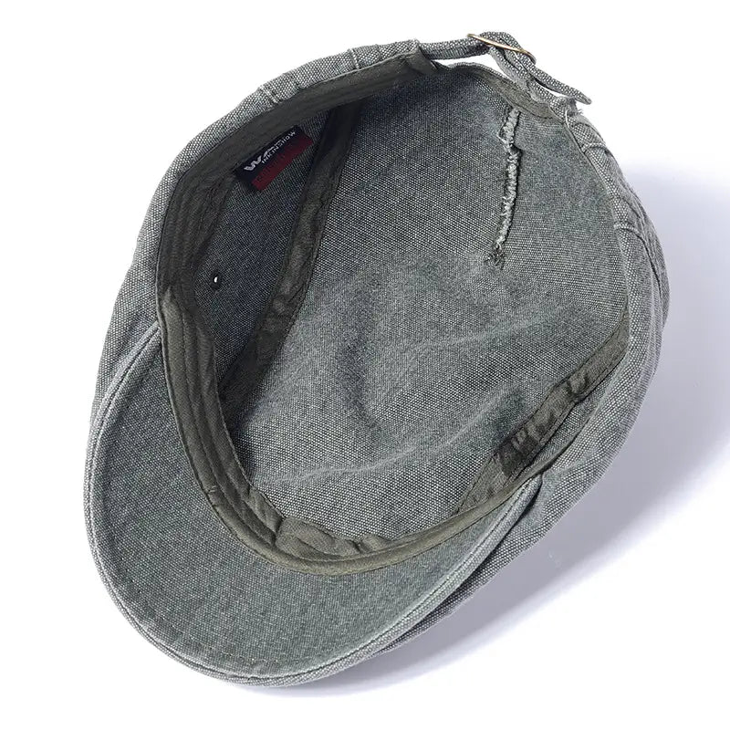 Eine graue, strukturierte Baumwoll-Denim-Flachmütze im Vintage-Béret-Stil mit geformtem Schirm und verstellbarem Riemen