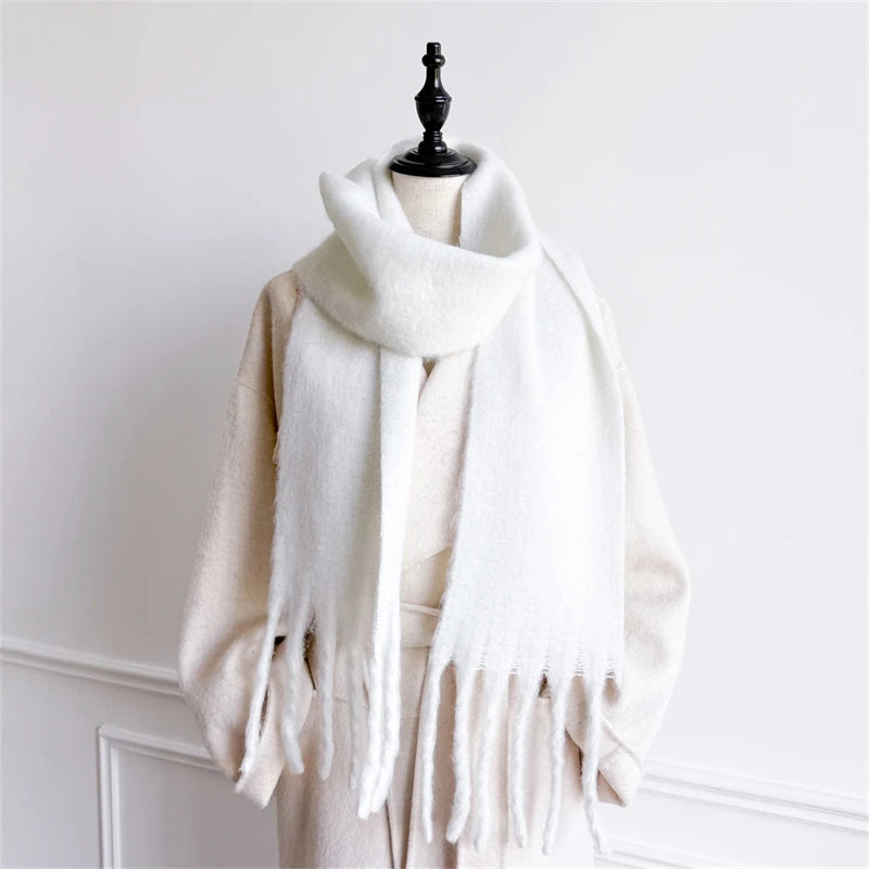 Ein flauschiger weißer Damenschal mit Cashmere-ähnlichem Gefühl für den Winter mit weicher, samtig-flauschiger Textur und langen gefransten Enden.