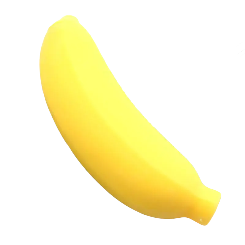 A bright yellow banana-shaped slow rising squishy toy rests on green palm fronds in a top view