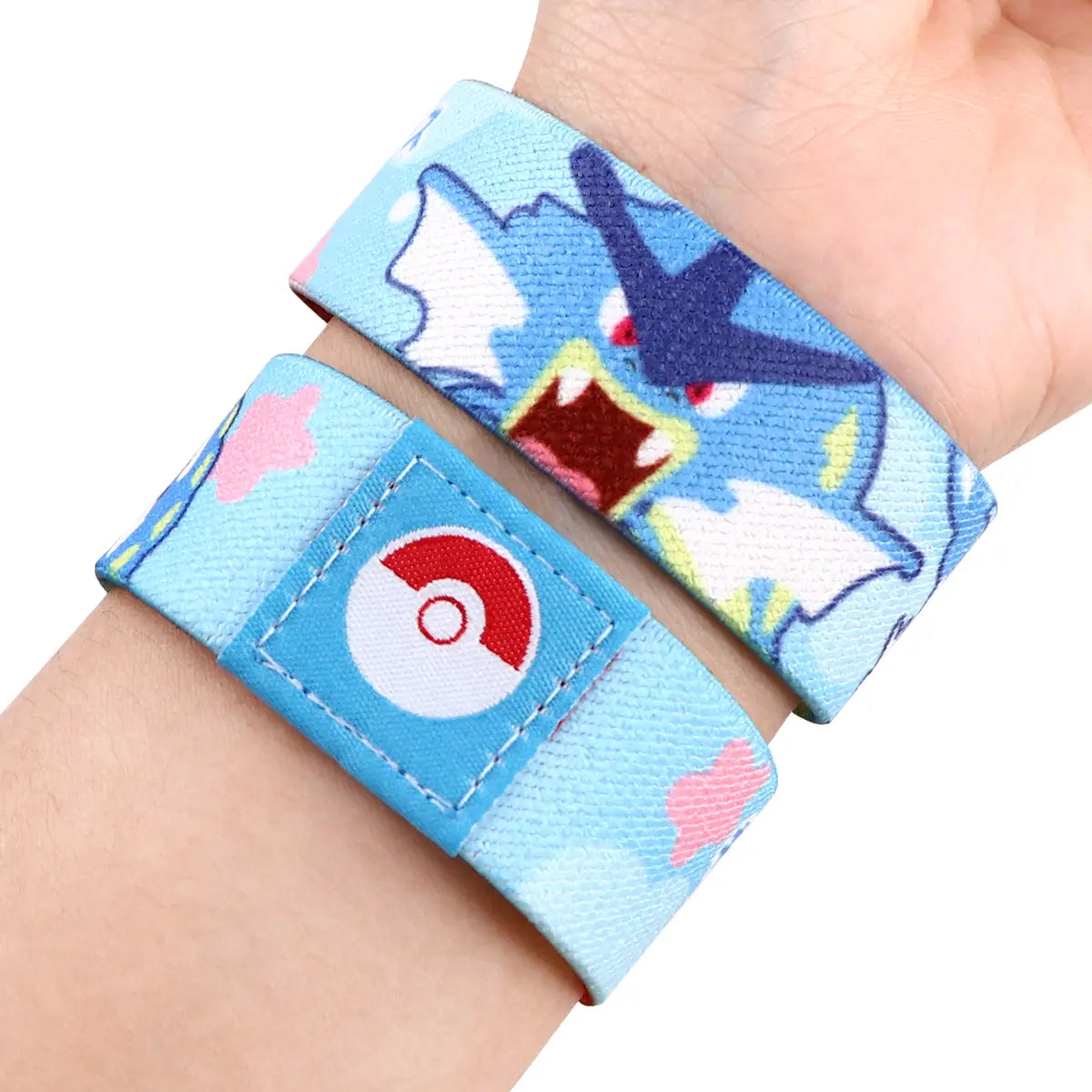 light blue stretch wristband bracelet made of elastic fabric featuring a cartoon pokémon character and a red and white poké ball logo patch