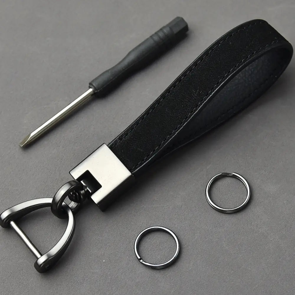 Black leather minimalist car keychain with a silver-toned metal d-ring and rectangular connector.