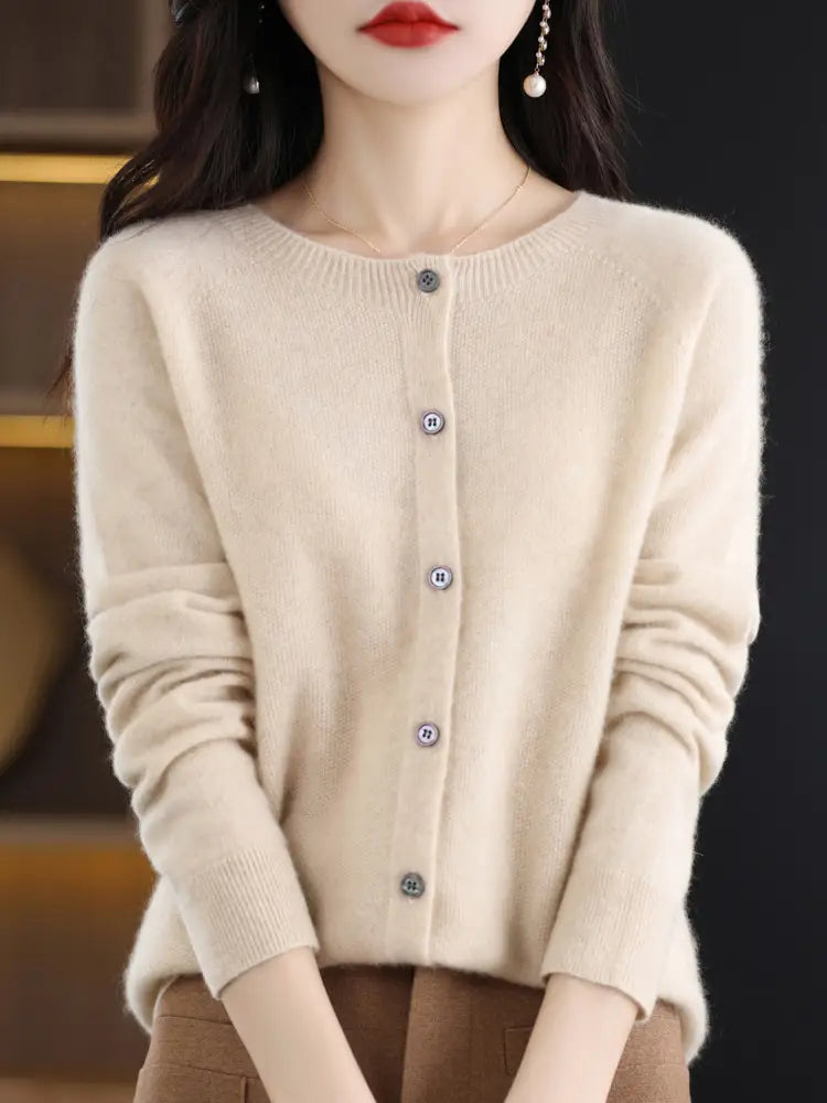 Cream-colored merino wool cardigan for women featuring long sleeves, subtle texture, and matching buttons down the front.