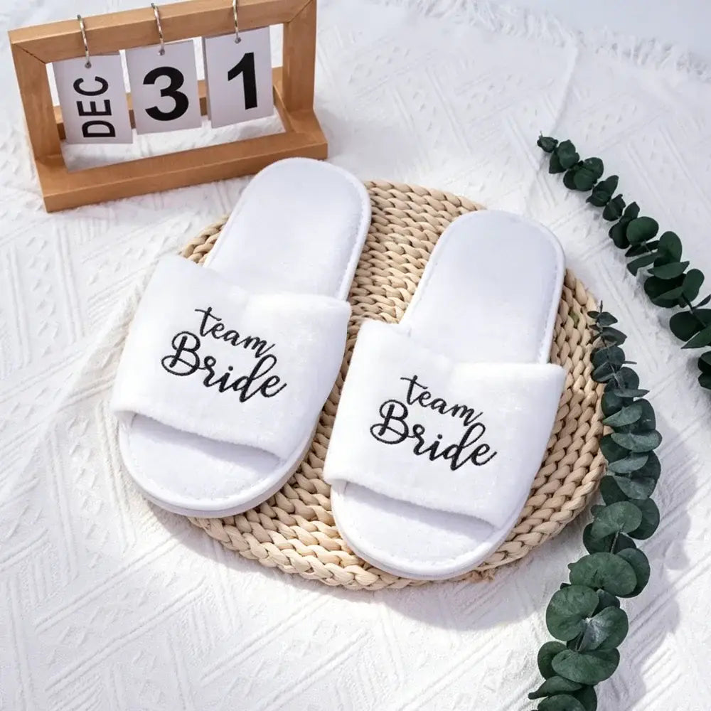 Weiße Team-Bräute-Slide-Sandalen mit schwarzer Kalligrafie-Schrift für das Schuhwerk der Hochzeitsgesellschaft.