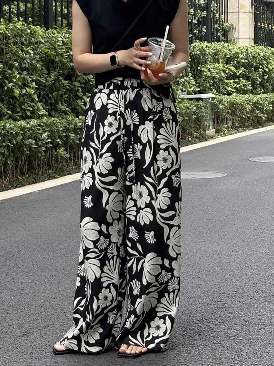pantalons à jambes évasées et imprimé floral pour femmes, noir et blanc, avec un imprimé floral audacieux et une coupe confortable à jambes évasées.