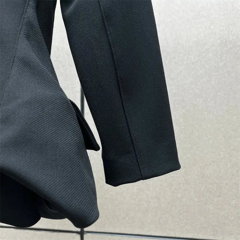 Manche en tissu texturé noir avec un motif côtelé discret et une couture nette sur le produit « jupe crayon grise taille haute de longueur genou Y2K »