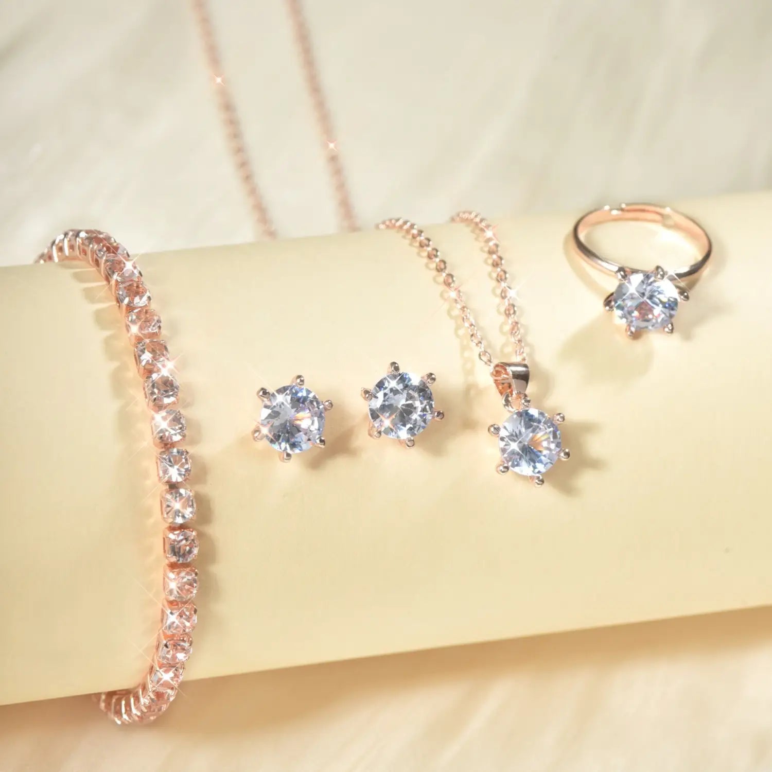 Pulsera de color dorado rosado con engaste de circonitas tipo diamante y piedras facetadas transparentes, dispuestas en una línea continua y elegante, del juego de joyería de circonita cúbica de 5 piezas.