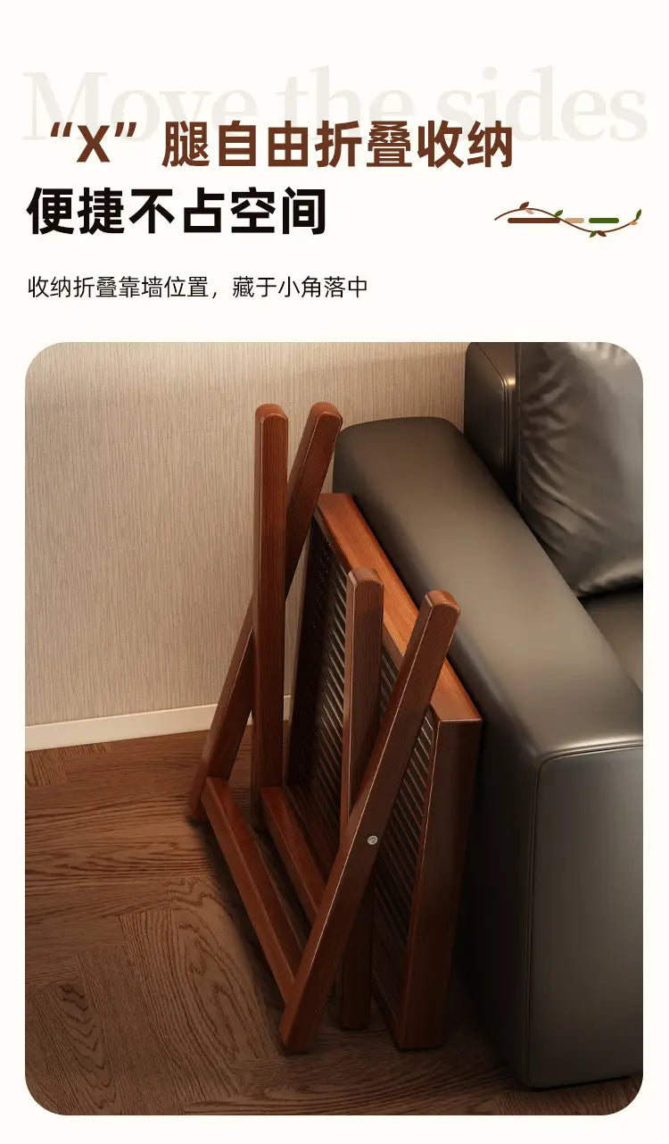 Brown wooden folding table with x leg design and glass top neatly stacked beside a sofa highlighting product selling points for foldable glass side table wood frame.