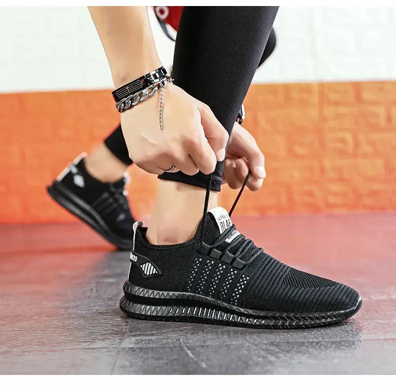 Herren-Atmungsaktive legere Strick-Sneaker mit schwarzem strukturiertem Mesh-Obermaterial und robuster, gemusterter Gummisohle.